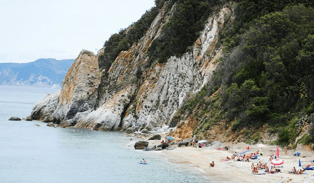 A cliffside beach filled with people | The Italian On Tour