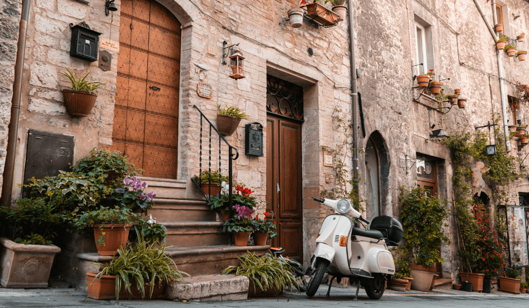 Scooter parked on a street with flowers in Assisi | The Italian On Tour