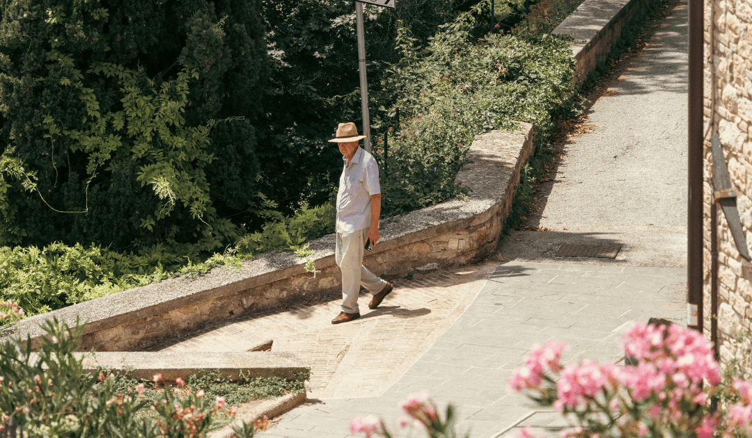 Man wearing a hat walking through Assisi