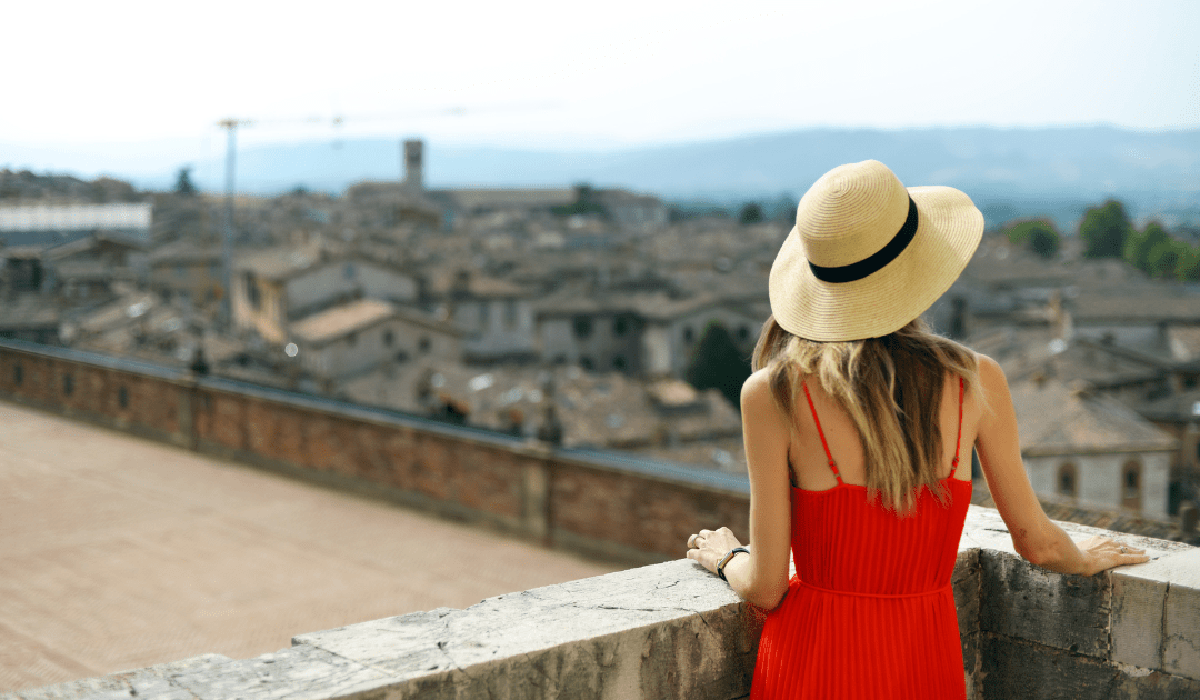 Woman in a red dress and sun hat in Umbria