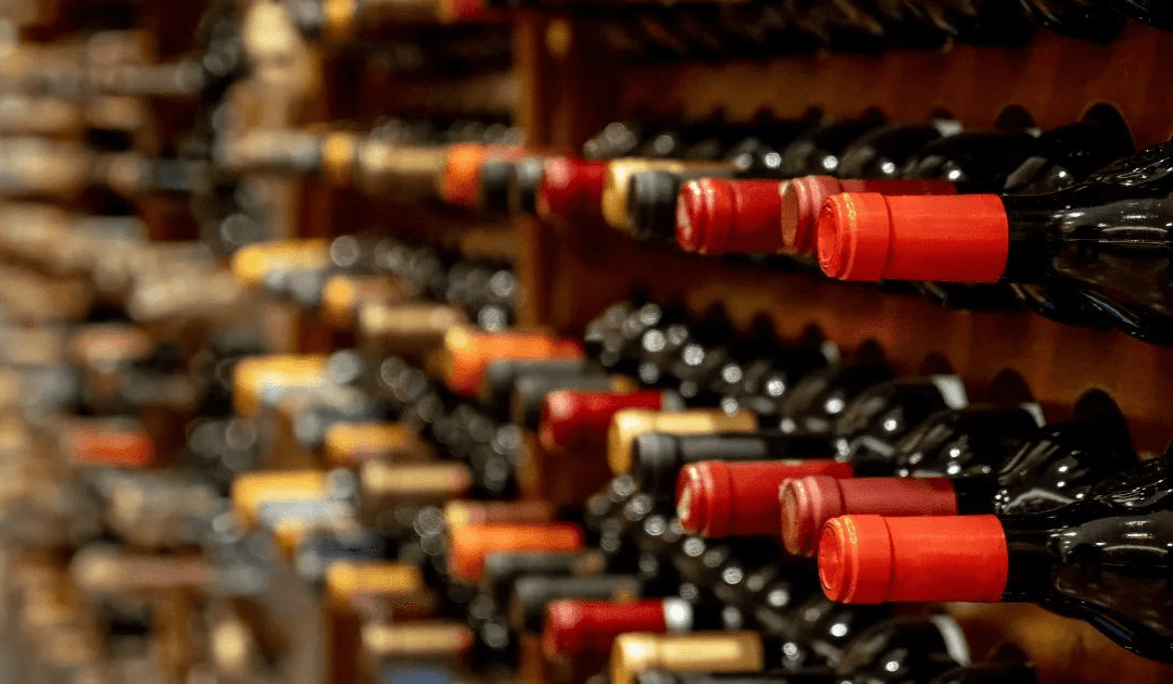 Zoomed in image of the neck of red wine bottles | The Italian On Tour