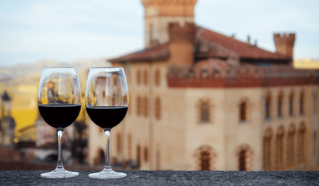 Two glasses of red wine on a balcony with a building in the background | The Italian On Tour