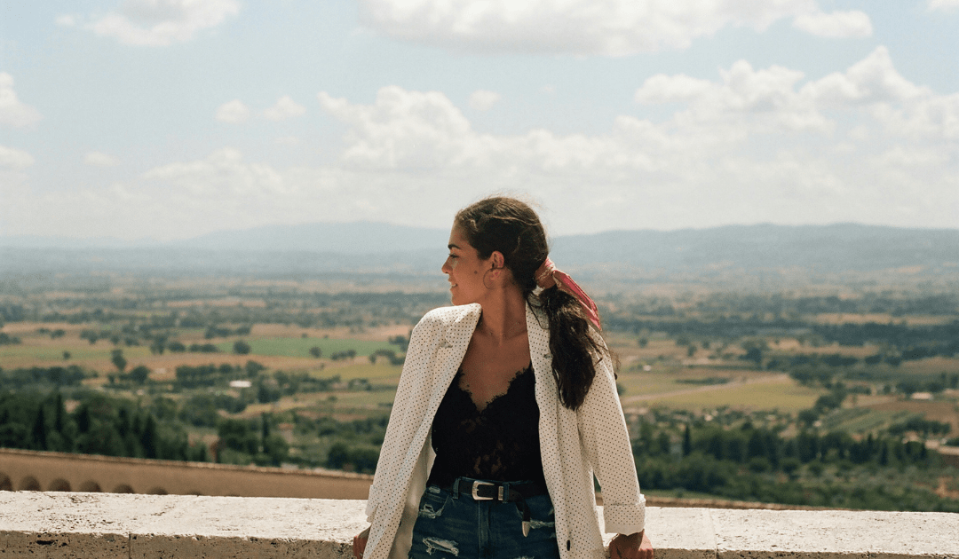 Woman standing near a wall overlooking a valley in Italy | The Italian On Tour